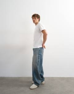 Model wearing 5 pack classic fit t-shirt in navy, ecru, pink, brown and blue