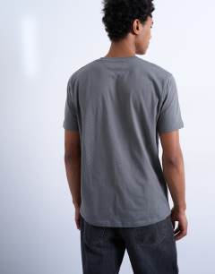 Model wearing 7 pack classic t-shirt in black, white, brown, navy, charcoal, ecru and brown 
