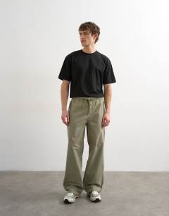 Model wearing Baggy fit canvas cargo trouser in olive green