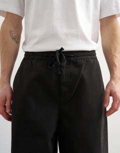 Model wearing Baggy fit herringbone trousers in black