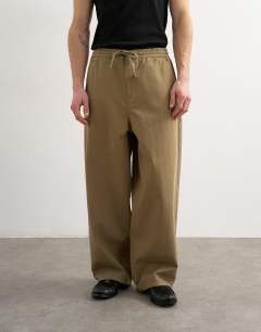 Model wearing Baggy fit herringbone trousers in khaki