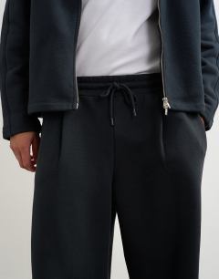 Model wearing Baggy fit scuba-style fabric heavyweight jogger with pleats in black