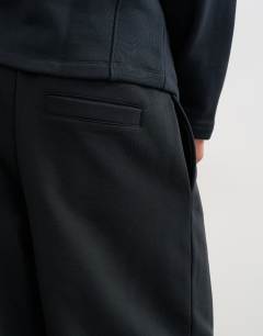 Model wearing Baggy fit scuba-style fabric heavyweight jogger with pleats in black