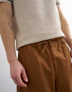 Model wearing Baggy fit trousers with side pockets in brown