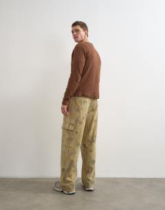 Model wearing Baggy fit twill camo print trousers in khaki
