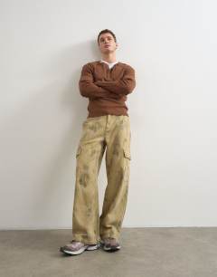 Model wearing Baggy fit twill camo print trousers in khaki