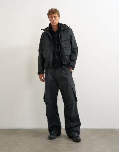 Model wearing Baggy fit waterproof nylon utility trouser in black