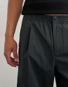 Model wearing Baggy fit waterproof nylon utility trouser in black