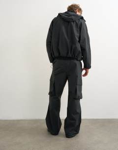 Model wearing Baggy fit waterproof nylon utility trouser in black
