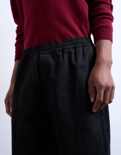 Model wearing Baggy trousers in twill with pintuck in black