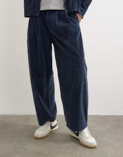 Model wearing Barrel fit cord trouser in washed blue