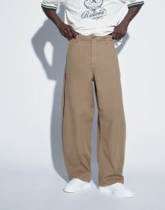 Model wearing Barrel fit trouser in tan