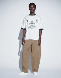 Model wearing Barrel fit trouser in tan