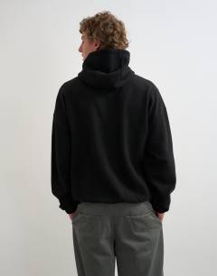 Model wearing Boxy fit funnel neck hoodie in black