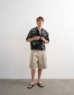 Model wearing Boxy fit heavyweight jersey shirt with all over floral applique in black