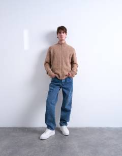 Model wearing Cable knitted zip through funnel neck cardigan in tan