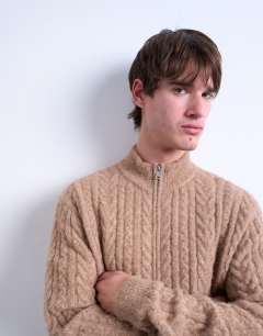 Model wearing Cable knitted zip through funnel neck cardigan in tan