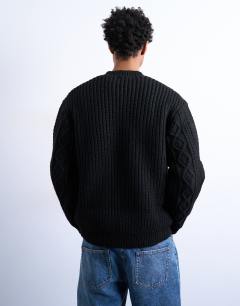 Model wearing Chunky cable knitted jumper in black