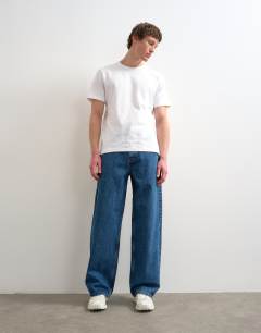 Model wearing Circular design rigid baggy jean in mid wash