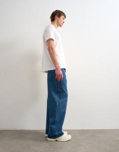 Model wearing Circular design rigid baggy jean in mid wash