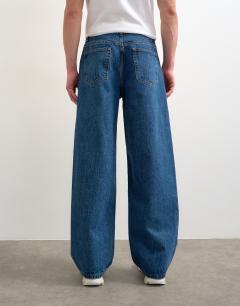 Model wearing Circular design rigid baggy jean in mid wash