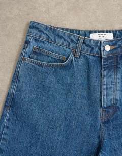 Model wearing Circular design rigid baggy jean in mid wash