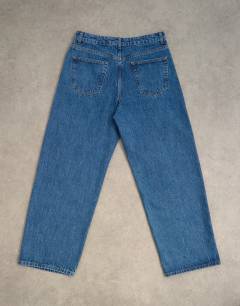 Model wearing Circular design rigid baggy jean in mid wash