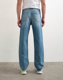 Model wearing Circular design rigid straight jean in mid wash
