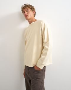 Model wearing Classic fit crop raglan sweatshirt with raw hem in ecru