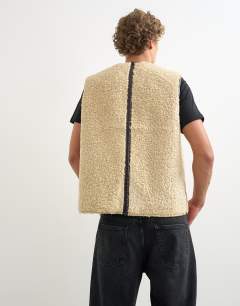 Model wearing Classic fit faux leather reversible shearling gilet in brown