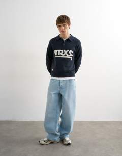 Model wearing Classic fit knitted rugby polo with applique text in navy