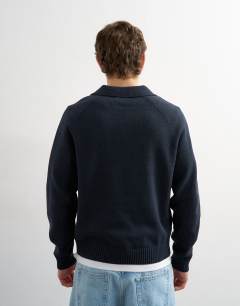 Model wearing Classic fit knitted rugby polo with applique text in navy