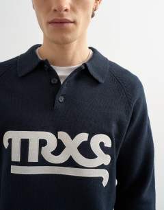 Model wearing Classic fit knitted rugby polo with applique text in navy