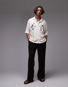 Model wearing Crop fit textured button through jersey shirt with floral embroidery in ecru