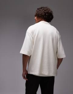 Model wearing Crop fit textured button through jersey shirt with floral embroidery in ecru
