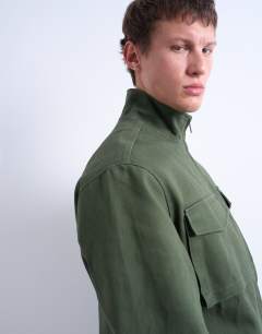 Model wearing Double pocket funnel neck canvas jacket in green