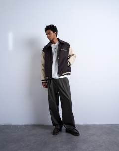 Model wearing Embroidered varsity jacket in brown