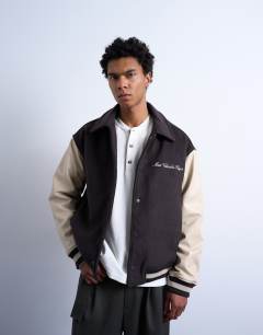 Model wearing Embroidered varsity jacket in brown