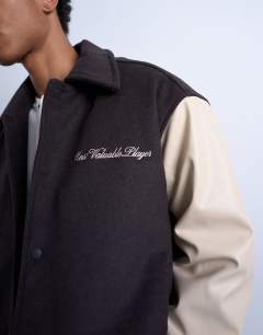 Model wearing Embroidered varsity jacket in brown