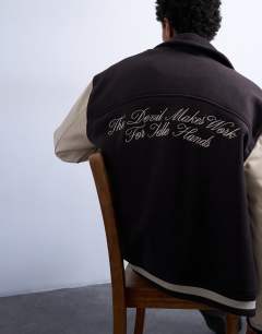 Model wearing Embroidered varsity jacket in brown