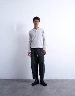 Model wearing Essential knitted button polo in light grey