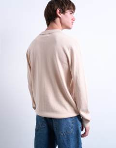 Model wearing Essential knitted button polo in stone