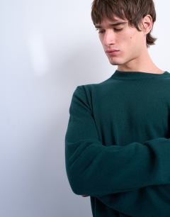 Model wearing Essential knitted crew neck in dark green