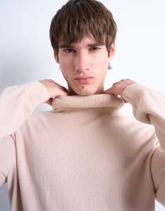 Model wearing Essential roll neck with wool in stone
