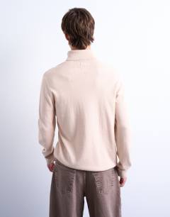 Model wearing Essential roll neck with wool in stone