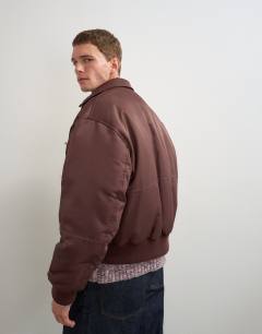 Model wearing Fireman clasp padded bomber jacket in burgundy