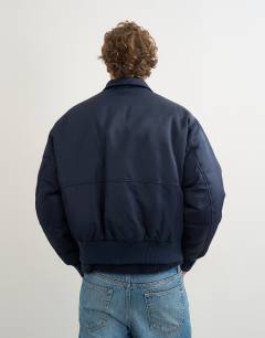 Model wearing Fireman clasp padded bomber jacket in navy