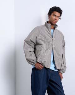 Model wearing Funnel neck check track jacket in brown