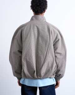 Model wearing Funnel neck check track jacket in brown