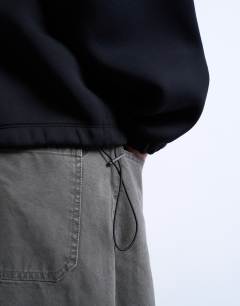 Model wearing Half zip funnel scuba-style fabric pullover in black